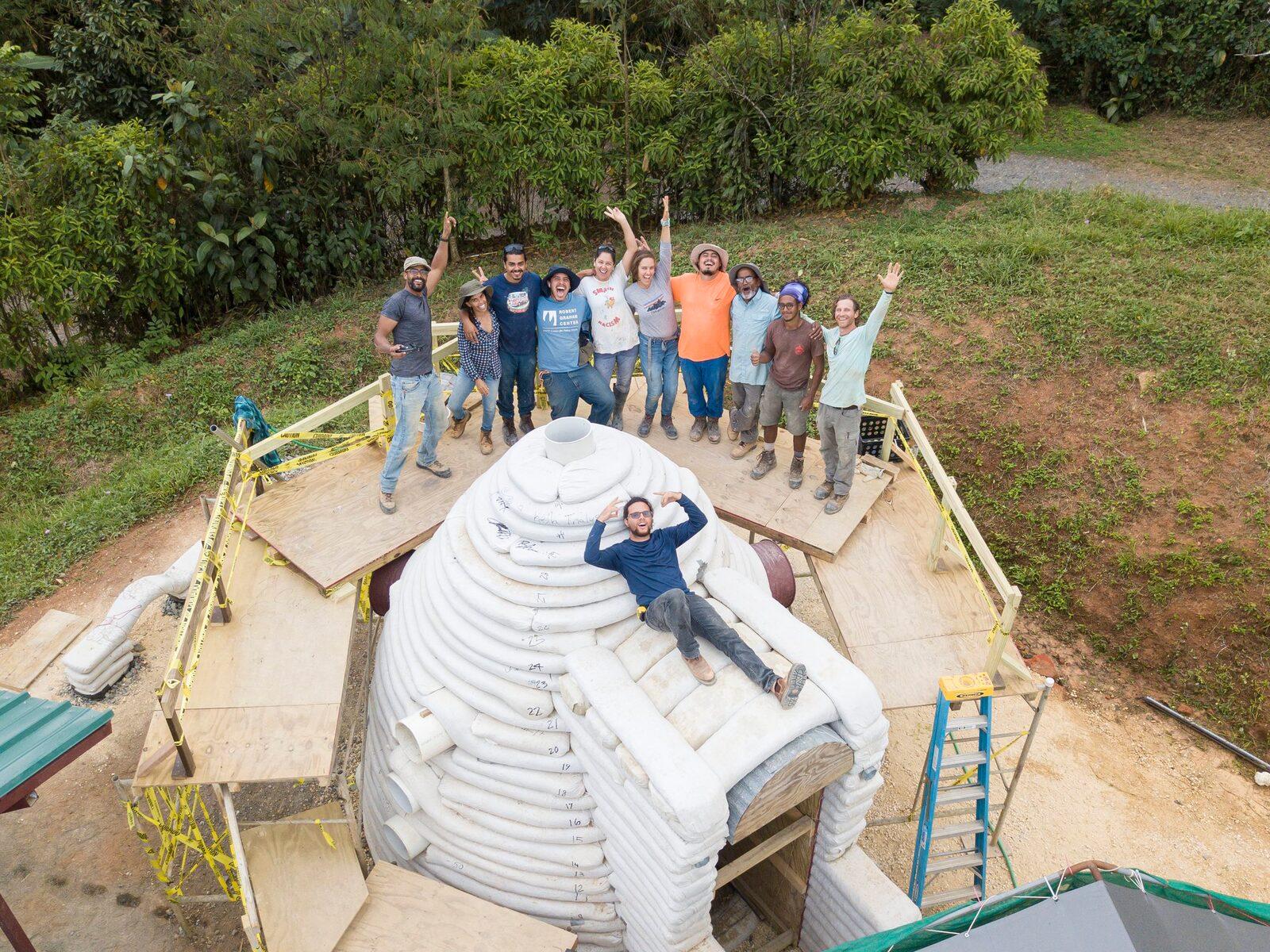 A residency group celebrating on a natural building they raised together
